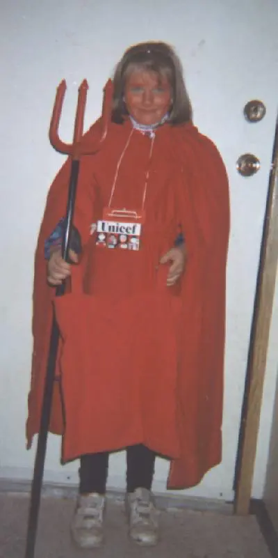 girl wearing a Halloween costume with a cape