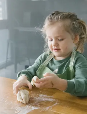 girl playing with child safe homemade dough