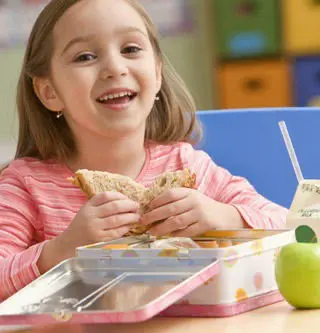 girl eating a sandwich at school lunch