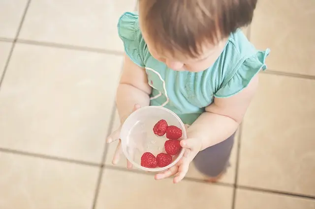  toddler with dish of straberries